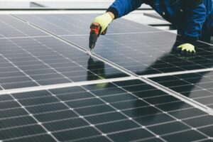 a person using a drill to fix a solar panel